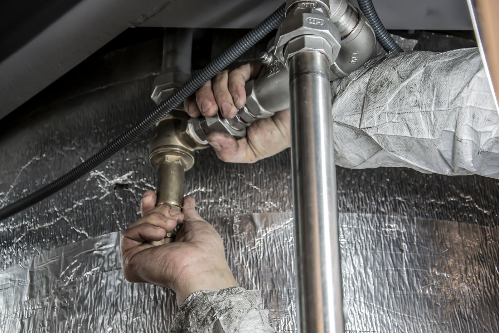 Plumber On Dial technician tightening pipe fittings on a service call